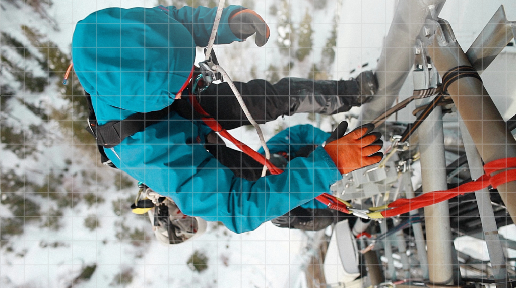 Engineer climbing a cell tower in snow