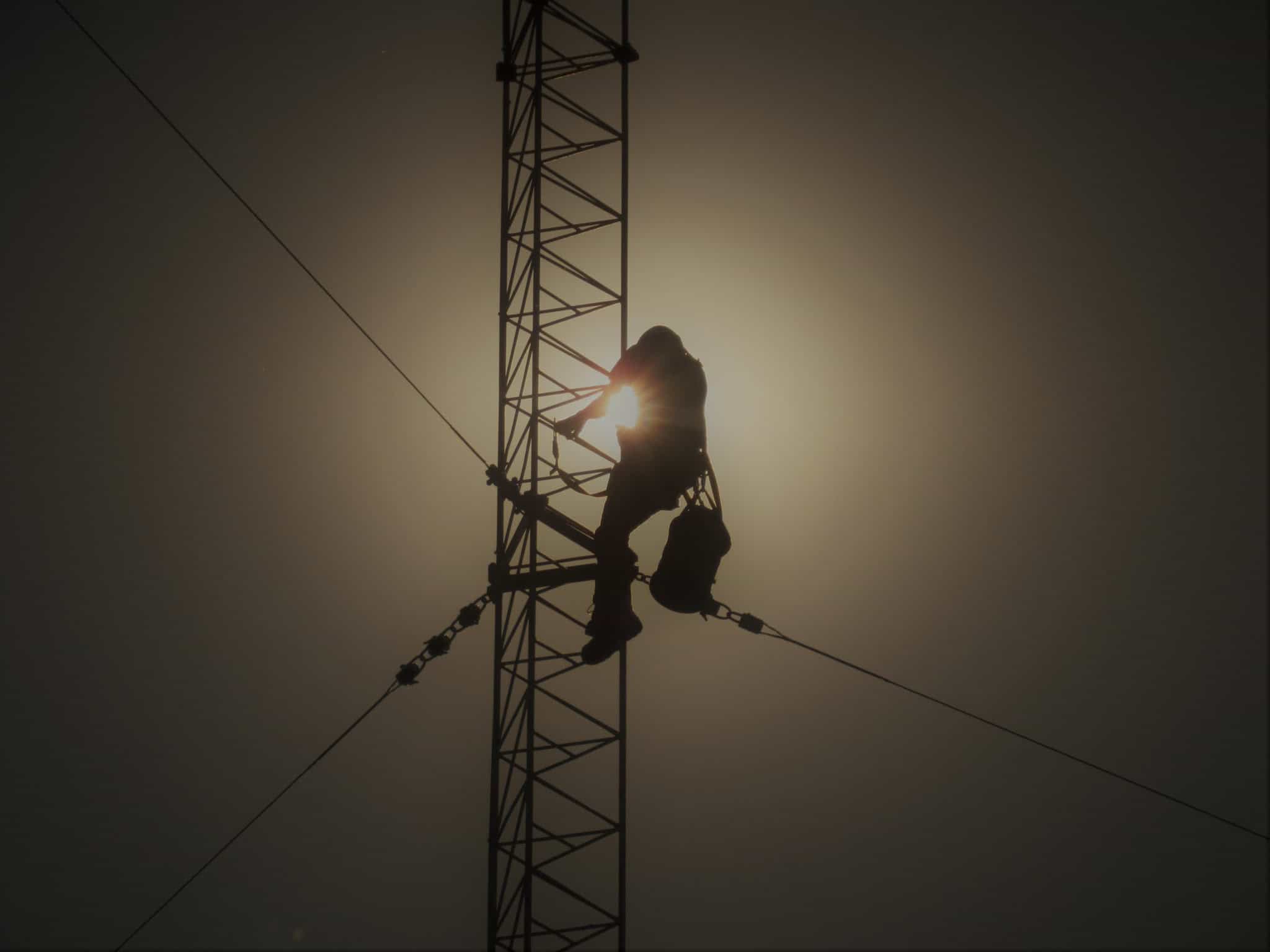 Worker climbing up tower at night
